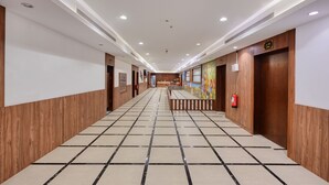 A hotel corridor with wooden paneling, tiled flooring, and recessed lighting. - Aluya Al Marwa Hotel (Jeddah)