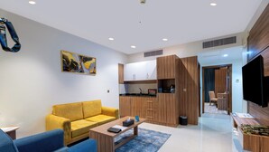 A modern living room with a sofa, coffee table, and a TV. - Aluya Al Marwa Hotel (Jeddah)
