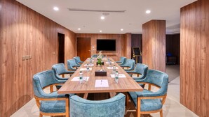 A conference room with a long table, blue upholstered chairs, and a flat-screen TV on the wall. - Aluya Al Marwa Hotel (Jeddah)