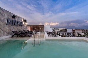 A rooftop pool area with lounge chairs and a bar. - Stilvolles Apartment mit Balkon an der Quinta (Playa del Carmen)