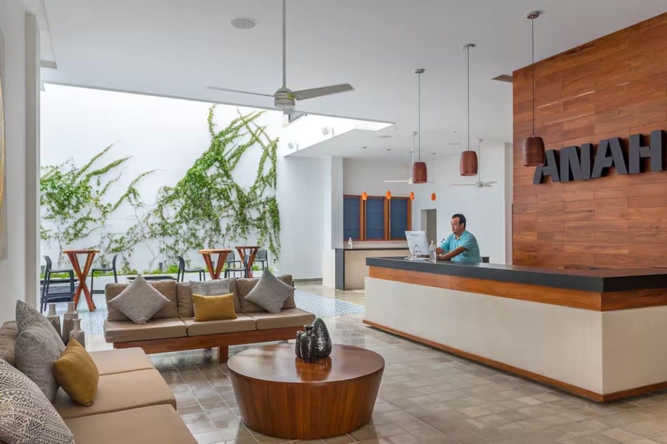 Un hall d’hôtel moderne avec un comptoir d’accueil, un canapé et une table basse.