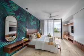 A modern bedroom with a large bed, a TV, a laptop, and a balcony with a view. - Stilvolles Apartment mit Balkon an der Quinta (Playa del Carmen)