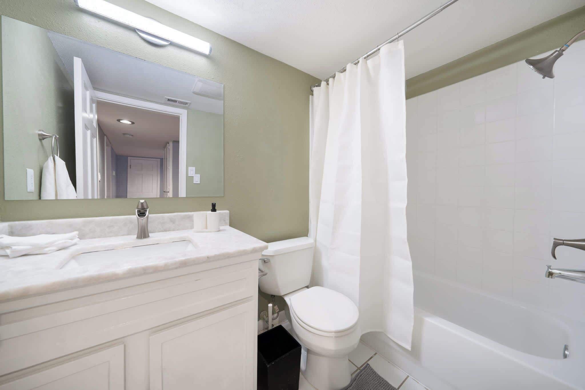 A bathroom with a white sink, toilet, and bathtub.