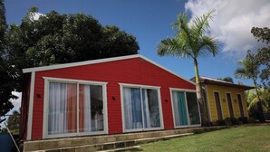 A red building with large windows and a small porch. - Cabaña Elian (Higüey)