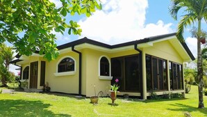 A yellow building with large windows and a covered patio area. - Villa and Casita (Tronadora)