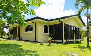 A yellow building with large windows and a covered patio area. - Villa and Casita (Tronadora)
