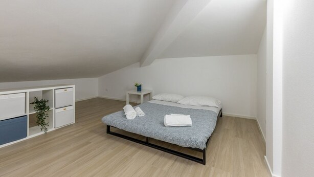 A bedroom with a bed, a small bedside table, a white wardrobe, and a plant. - A welcoming and spacious apartment of approximately 130 sqm—perfect for 8 guests—located within a villa in an exclusive neighborhood of Marina di Pietrasanta, bordering Forte dei Marmi.Its strategic location allows you to reach the sea in just 7 minu (Marina di Pietrasanta)
