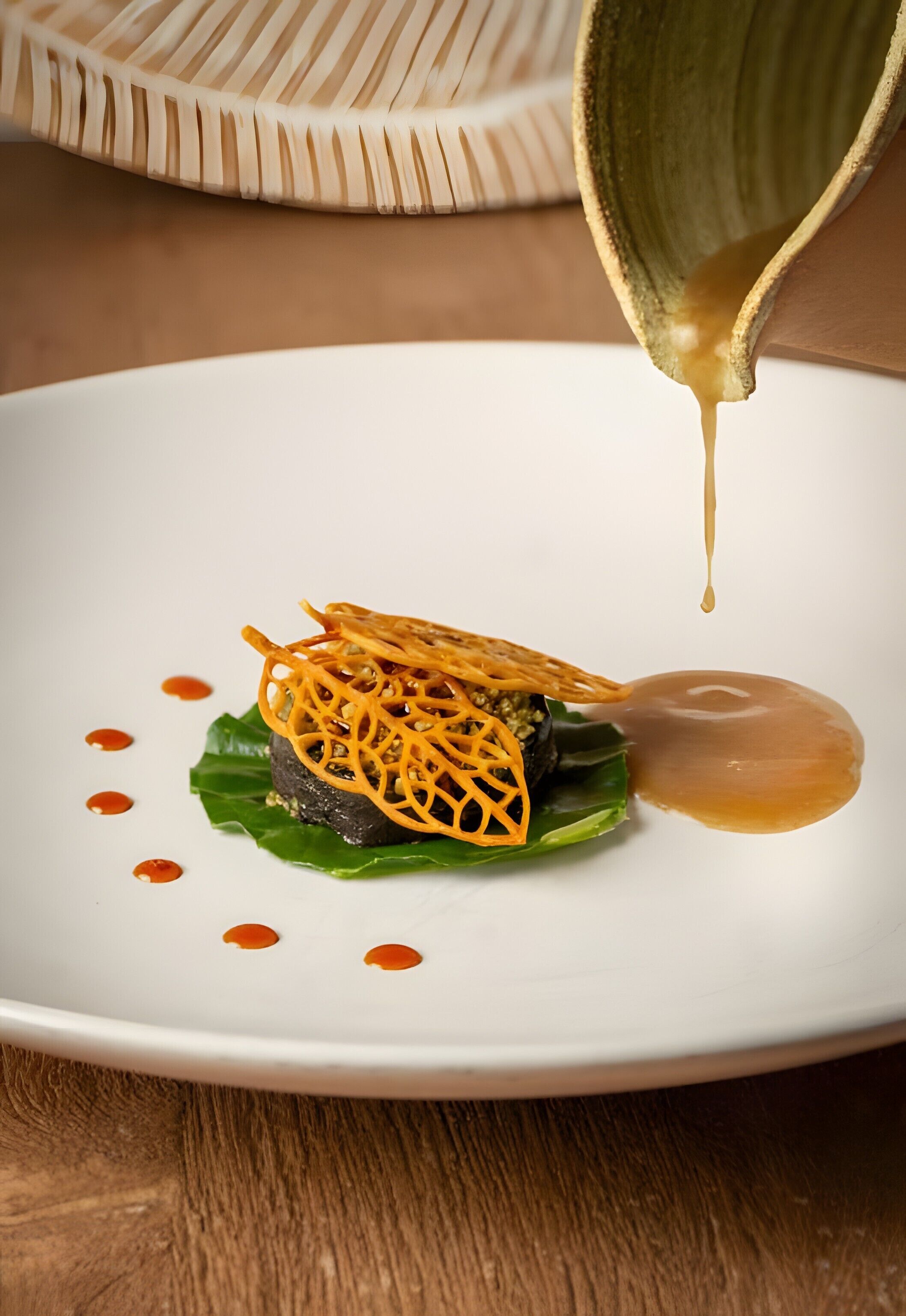 Un plato blanco con un guiso, un tazón y una cuchara.