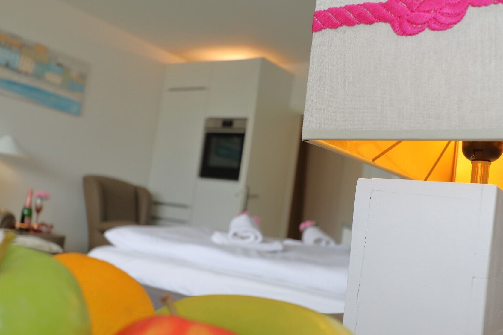 Une chambre d’hôtel avec un lit, une lampe et un tableau au mur.