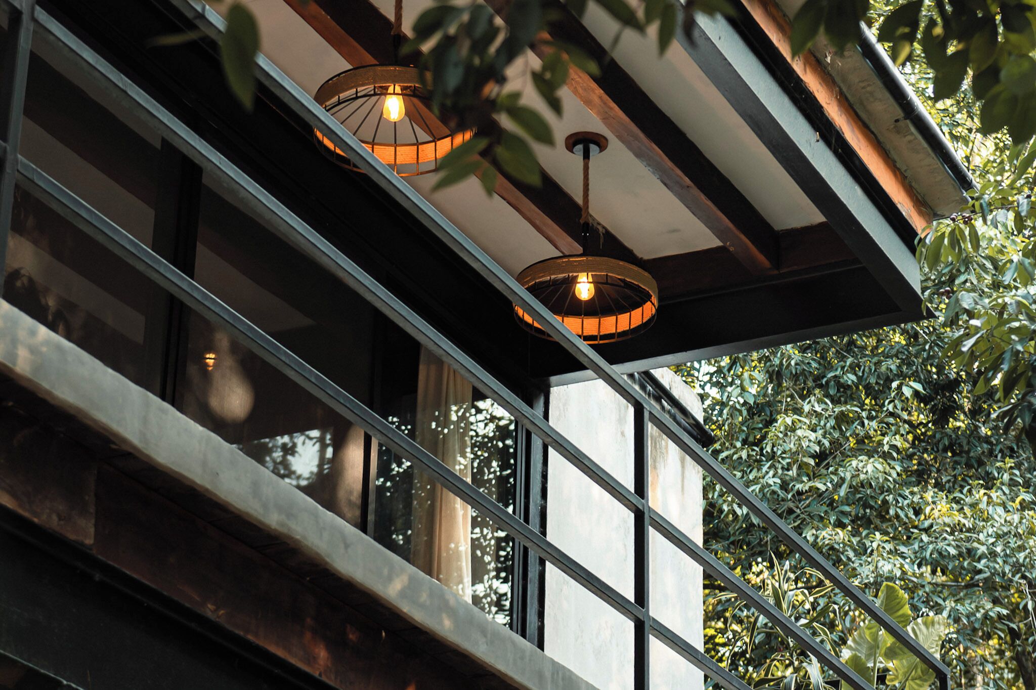 Un bâtiment moderne doté de grandes fenêtres et d’un balcon avec des garde-corps en métal.