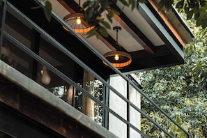 A modern building with large windows and a balcony with metal railings. - Casa Tattva Puerto Morelos (Leona Vicario)