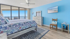 A bedroom with a bed, a dresser, a chair, a desk, and a ceiling fan. - 🏊🥽🌴Ebb Tide 406 | NSB's Finest | New Pool + Sundeck + Beach Access (New Smyrna Beach)