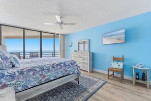 A bedroom with a bed, a dresser, a chair, a desk, and a ceiling fan. - 🏊🥽🌴Ebb Tide 406 | NSB's Finest | New Pool + Sundeck + Beach Access (New Smyrna Beach)