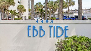 A building with the sign 'Ebb Tide' and the number '4493' on a white wall. - 🏊🥽🌴Ebb Tide 406 | NSB's Finest | New Pool + Sundeck + Beach Access (New Smyrna Beach)