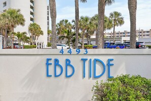 A building with the sign 'Ebb Tide' and the number '4493' on a white wall. - 🏊🥽🌴Ebb Tide 406 | NSB's Finest | New Pool + Sundeck + Beach Access (New Smyrna Beach)
