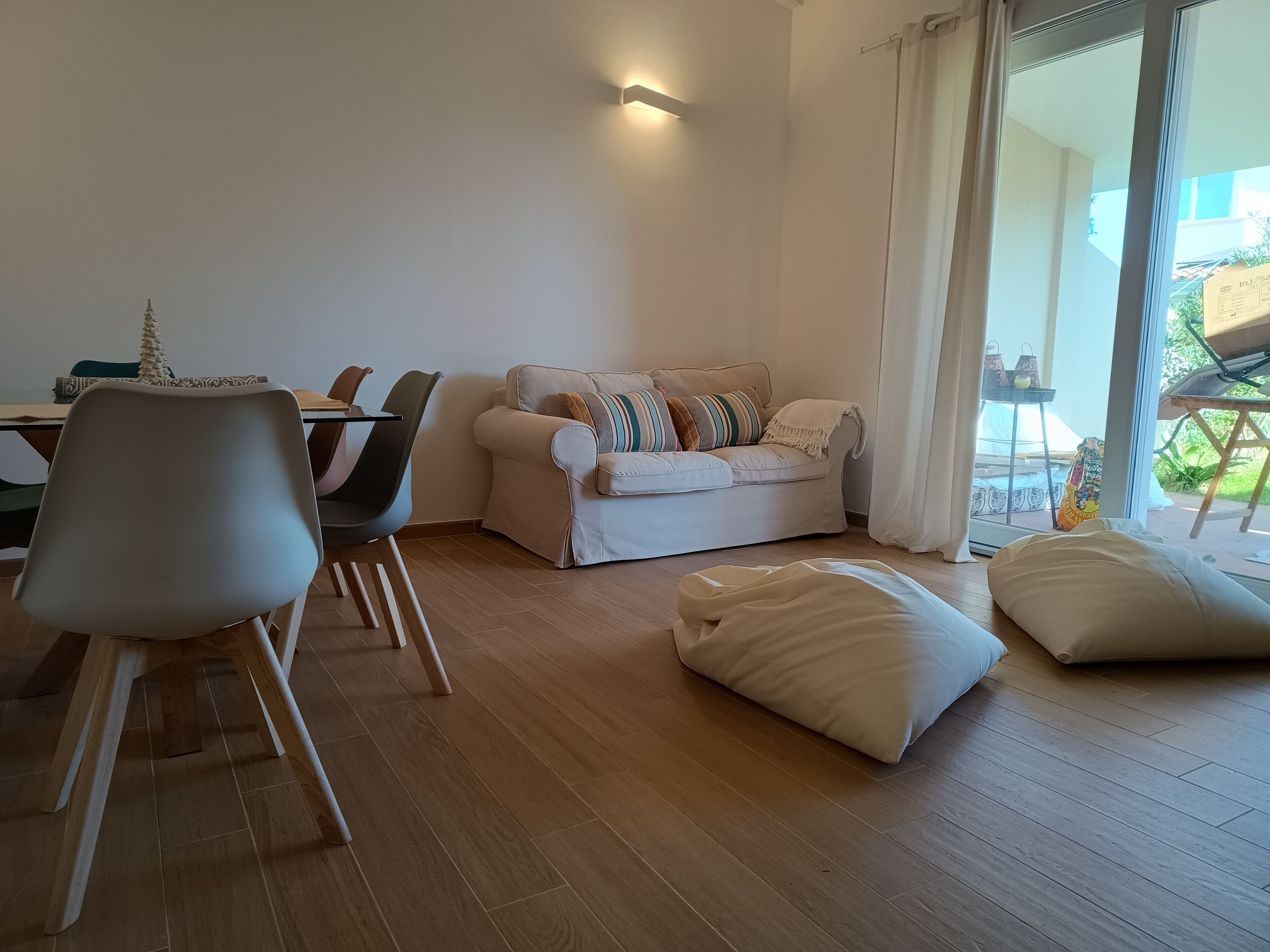 Un salon moderne avec un canapé, une table à manger, des chaises et une grande fenêtre.
