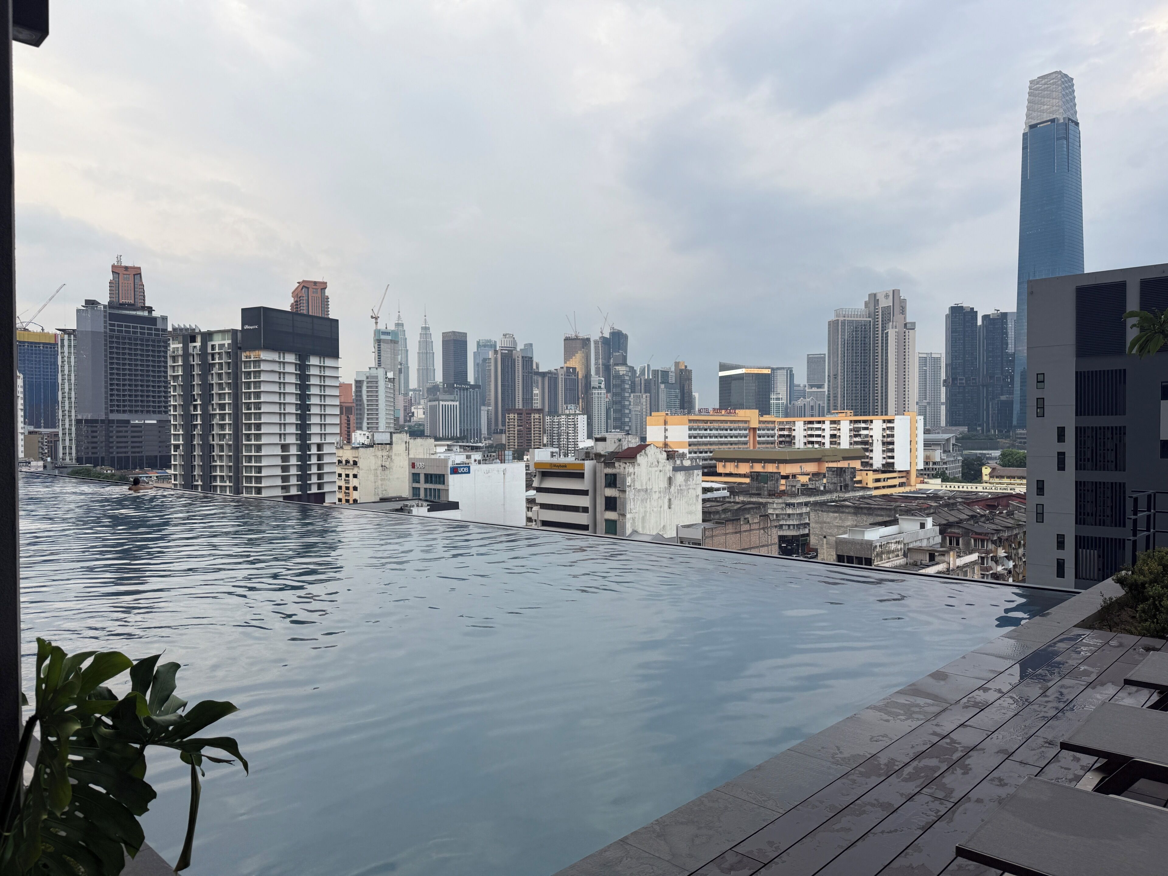 Una piscina en la azotea con vistas a un paisaje urbano, que incluye edificios altos y un hotel.