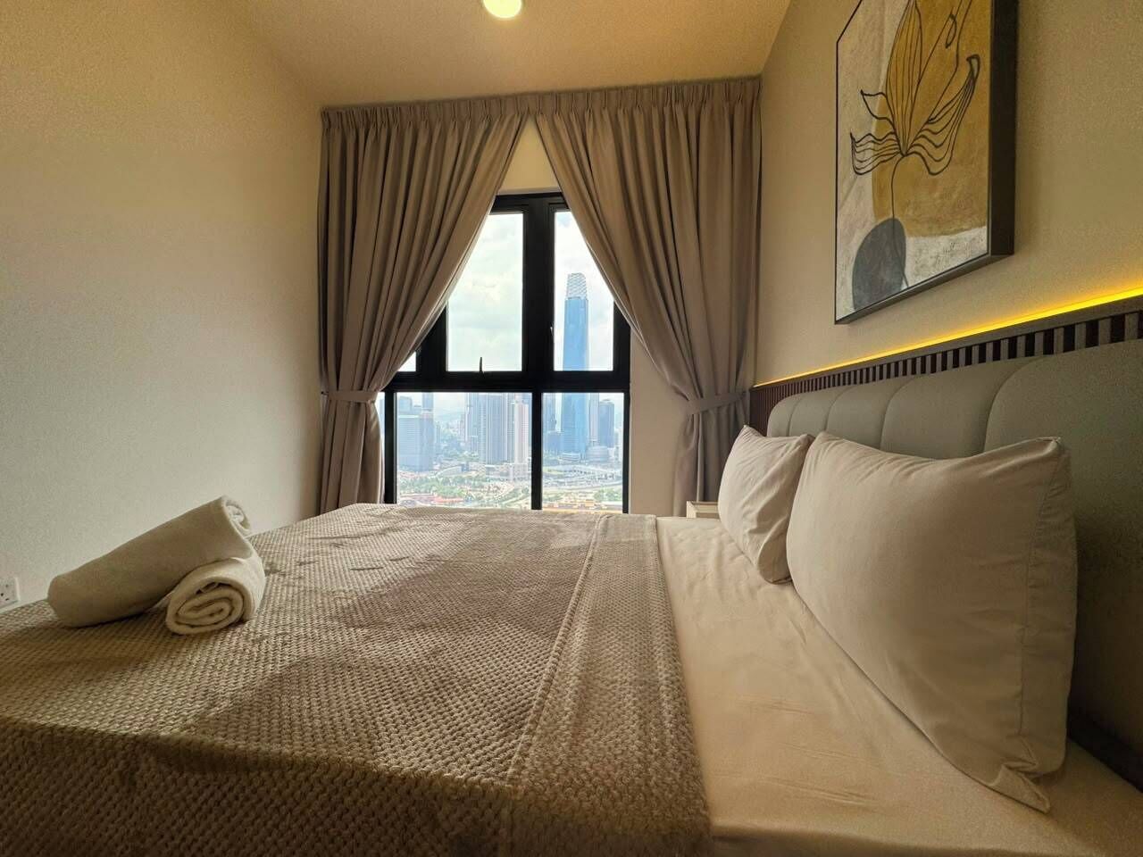 Habitación de hotel con una cama grande, vistas de la ciudad y un cuadro en la pared.