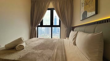 Habitación de hotel con una cama grande, vistas de la ciudad y un cuadro en la pared.