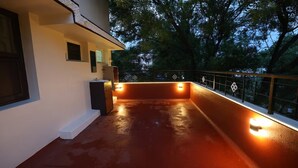Un balcón con barandilla, un lavabo y una ventana.