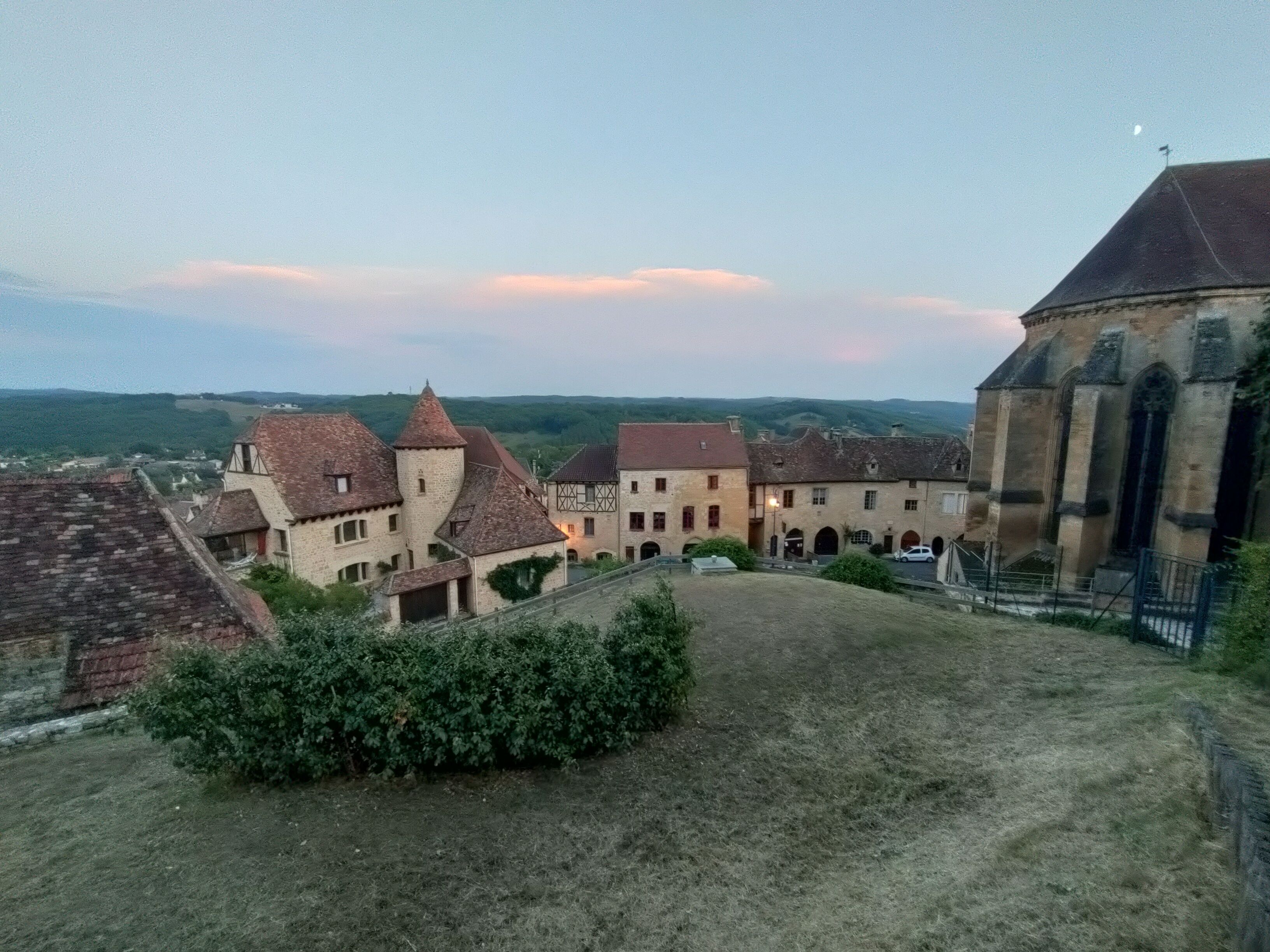 A historic building complex with multiple structures, including a church with a prominent bell tower.