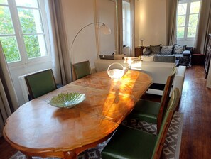 A dining area with a wooden table, chairs, and a view of the outdoors. - 2-room Country House in the Heart of Quercy-Périgord (Gourdon)