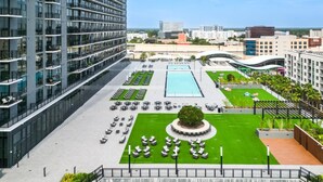 A modern hotel with multiple floors, outdoor pools, and a well-maintained garden area. - Landing Amazing Studio (Orlando)