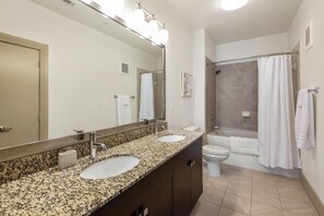 A bathroom with two sinks, a toilet, a shower, and a large mirror. - Landing Beautiful 1bd, Courtyard, Clubhouse (Goodyear)