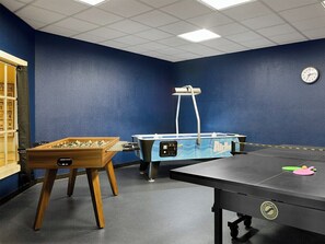 Ein Raum mit Tischfußball, Pong-Tisch und Billardtisch.