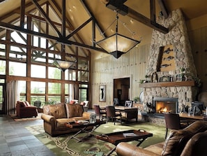 A spacious living room with a stone fireplace, leather furniture, and large windows. - Family-Friendly 1 Bedroom Villa Willow Ridge Lodge (Branson)