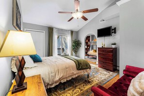 A bedroom with a bed, a ceiling fan, a TV, a dresser, and a red chair. - 6BR, Sleeps 16, Game Room, Hot Tub, Resort Access (Albrightsville)