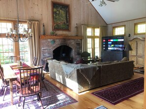 Ein gemütliches Wohnzimmer mit Kamin, Holzmöbeln und einem Fernseher.