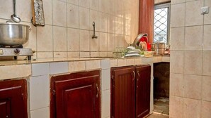 Une cuisine équipée d’une cuisinière, d’une casserole suspendue et d’une fenêtre donnant sur un beau paysage.