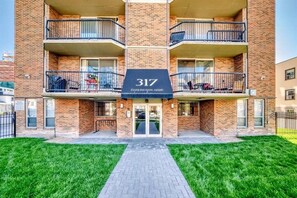 A multi-story brick building with a sign reading '317 DARLINGTON ARMS.' - Urban Downtown Condo with Panoramic Views (Calgary)