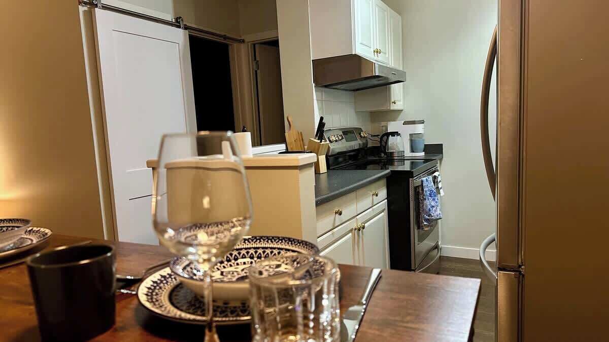 A kitchen with white cabinets, a stove, and a refrigerator.
