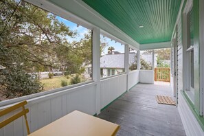 A covered porch with a table and chairs, a view of the backyard, and a wooden fence. - Private Balcony Apartment Near Historic Downtown (St. Augustine)