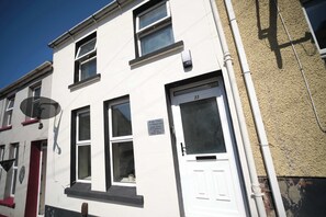 A multi-story residential building with a white facade, numbered 23, and a satellite dish on the left. - 3 Bed Foyle View House In Derry City With Parking (Derry/Londonderry)