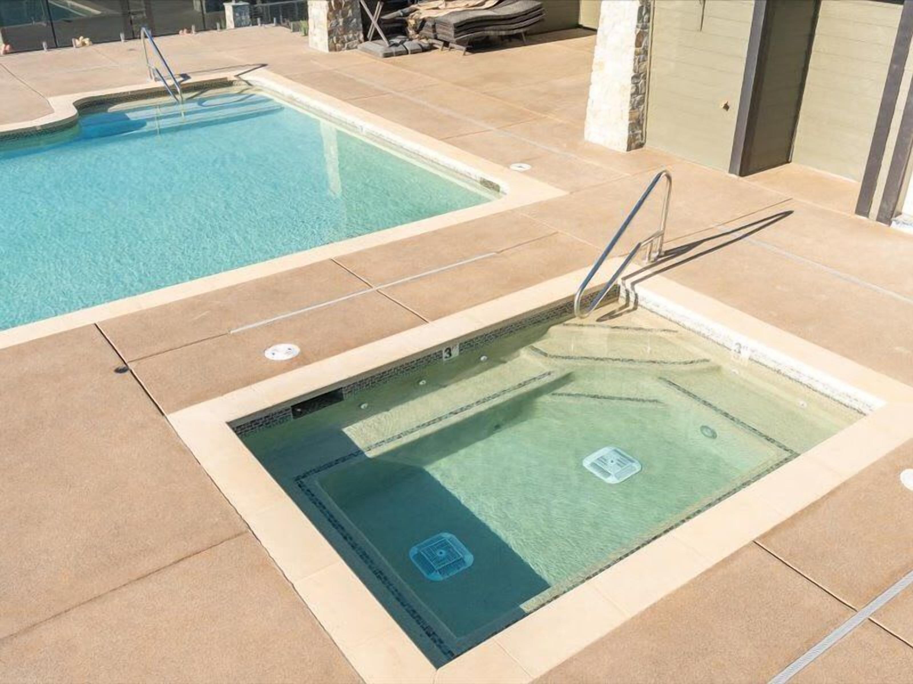 Ein Schwimmbecken mit Sprungbrett und einem abgegrenzten flachen Bereich.