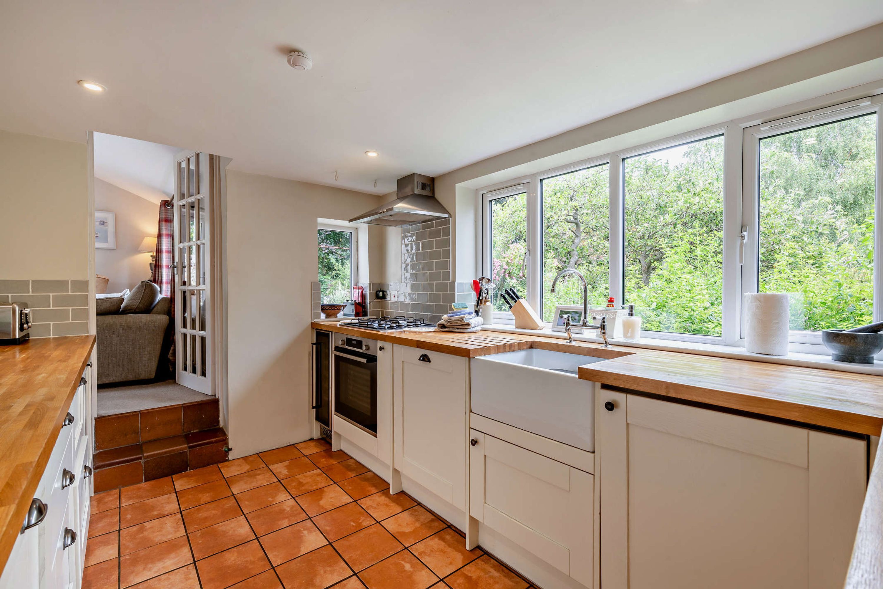 A modern kitchen with a large window, a built-in oven, and a sink.
