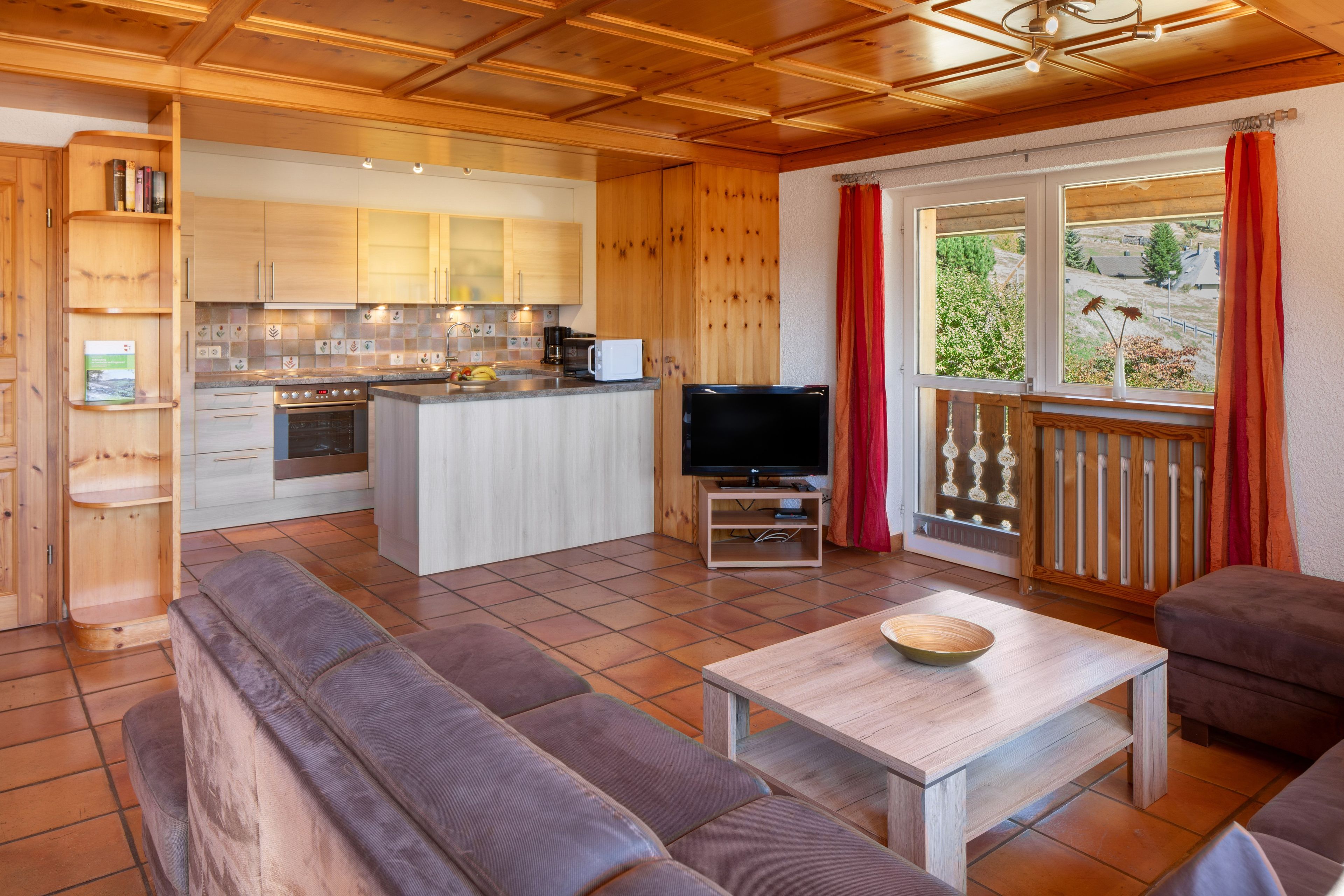 Une cuisine moderne avec des meubles en bois, un four encastré et un four à micro-ondes.