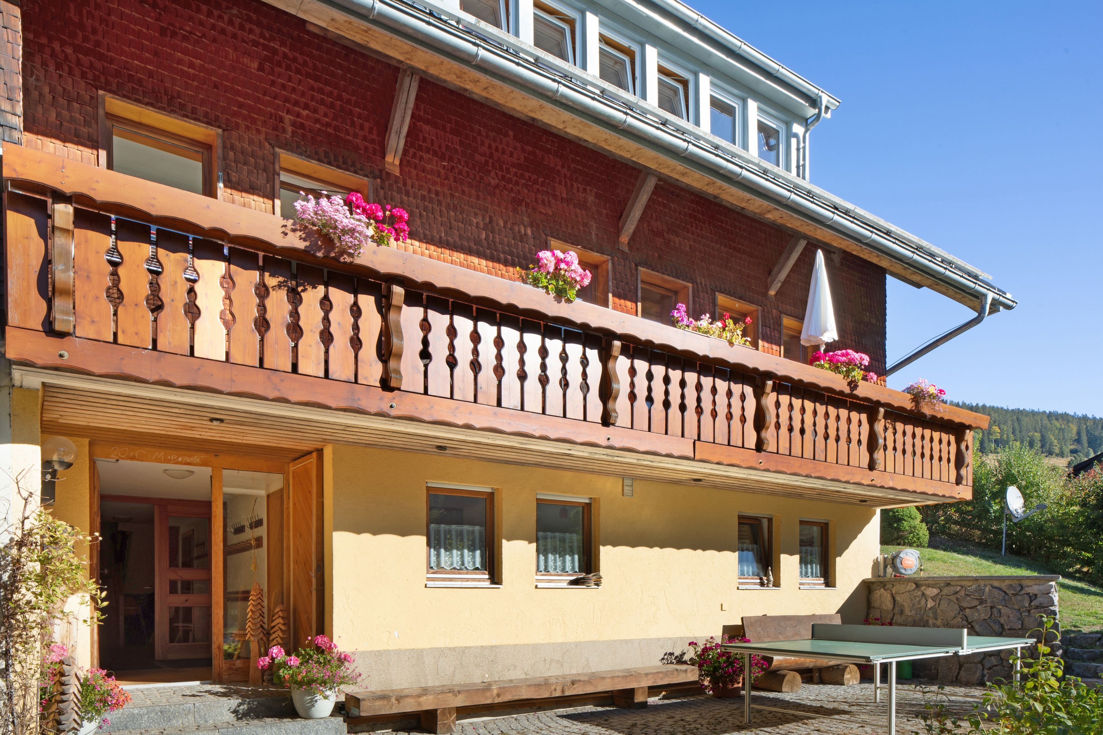 Un bâtiment à deux étages doté d’un balcon, de fenêtres et d’un mur en pierre.