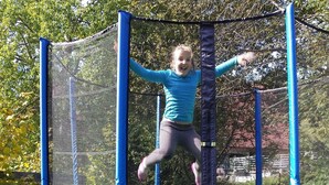 A child jumping on a trampoline with safety netting. - Apartment 4 at Gästehaus Bühlhof in Todtnauberg (Todtnau)