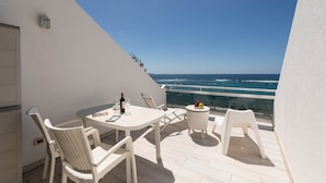 A balcony with a table and chairs, a bottle of wine, and a fruit bowl. - Apartment in Las Palmas by Las Canteras Beach (Las Palmas de Gran Canaria)