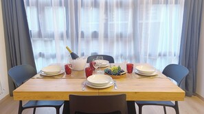 A dining table set with plates, glasses, a bottle of champagne, and a bowl of fruit. - Apricola By ca-sa check (Aprica)