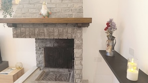 A fireplace with a stone facade, a shelf above it, and a candle on the right. - Apricola By ca-sa check (Aprica)