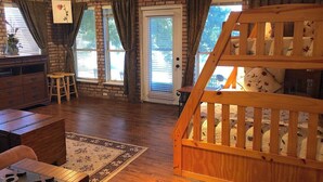 A room with a wooden staircase, a dining area with a table and chairs, a fireplace, and a large window with curtains. - 11 Luxury Acres Retreat, Pool, Fishing, Sleeps 14-24 (Mabank)