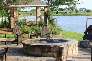 A gazebo with a swing chair, a fire pit, and outdoor seating. - 11 Luxury Acres Retreat, Pool, Fishing, Sleeps 14-24 (Mabank)