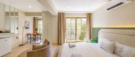 A hotel room with a bed, a desk, a chair, and a view of the outside.