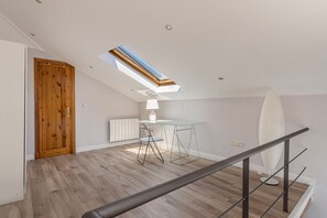 Ein zeitgemäßes Interieur mit Holztür, Oberlicht, weißem Tisch mit Stühlen und einer weißen Heizkörper.