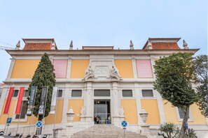 A building with a classical facade, a central entrance, and a staircase leading up to it. - Studio 'Madragoa Cozy Studio' (Lisbon)